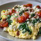 Scrambled eggs, sautéed spinach, and creamy feta combine in this vibrant Spinach and Feta Breakfast Bowl, served with crunchy toast.