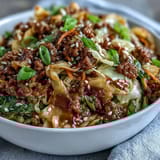 Spicy Egg Roll in a Bowl served hot in a white bowl, topped with sesame seeds and fresh green onions.