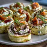 Elegant smoked salmon and cucumber cream cheese pinwheels with dill, rolled in soft tortillas and sliced for a perfect party appetizer.