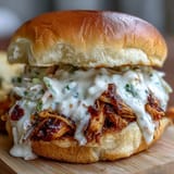 Tangy Alabama white BBQ sauce generously drizzled over tender smoked pulled chicken.