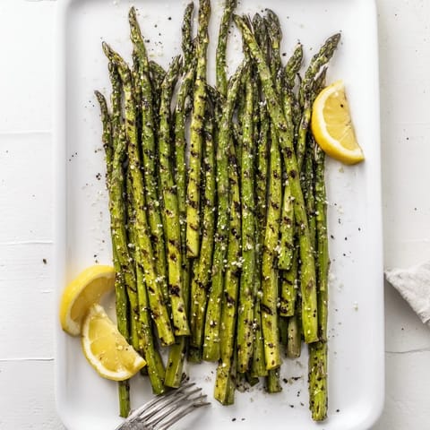 Grilled Asparagus lightly seasoned with olive oil and flaky salt, ready to serve alongside grilled salmon or steak.