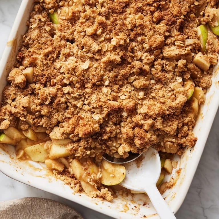 Homemade Apple Crumble dessert cooling on a rack, showcasing a crunchy brown sugar and oat crumble over apples.
