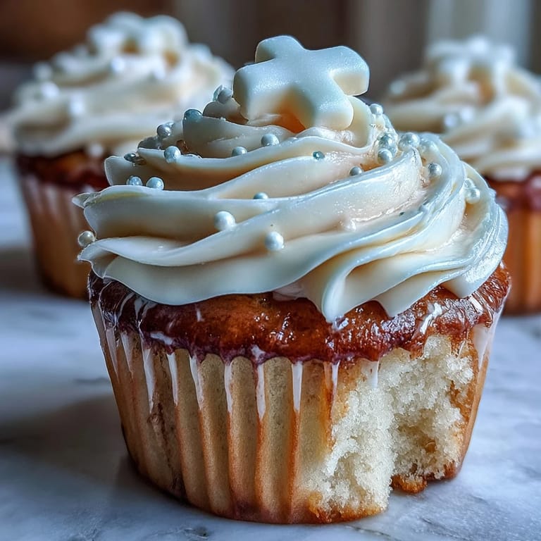 Beautifully frosted communion cupcakes featuring elegant, handcrafted white fondant crosses for celebration.
