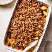 Freshly baked Apple Crumble with warm cinnamon apples and a golden oat crumble topping, served with vanilla ice cream.