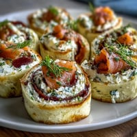 Elegant smoked salmon and cucumber cream cheese pinwheels with dill, rolled in soft tortillas and sliced for a perfect party appetizer.