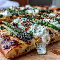 Roasted asparagus flatbread topped with creamy burrata and bright lemon zest.
