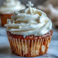 Delicate vanilla communion cupcakes adorned with a creamy frosting and fondant cross.